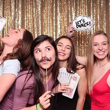 An image of a bunch of happy ladies using our photo booth and striking a pose with photo booth props