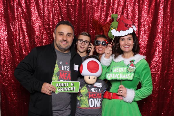 An image of a family posing in front of our red sequin backdrop at a corporate Christmas party we did in Edmonton