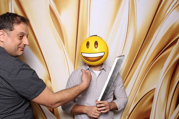 An image of two guys posing behind a gold stretch backdrop
